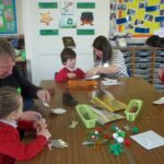 parent and pupils working on crafts at the table