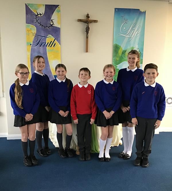 Image of School Council pupils standing under a cross and posters